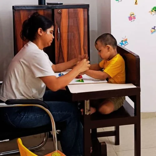 Therapist working with child in a focused table session for speech therapy